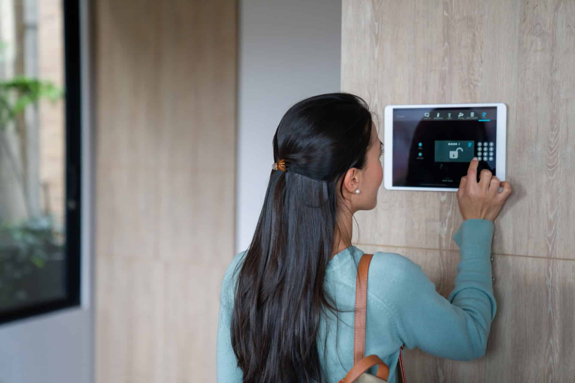 A woman arming her burglar alarm